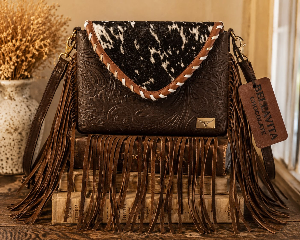 Bella Vita hand-tooled leather fringe shoulder bag in dark chocolate brown with speckled cowhide flap, long leather fringe, and gold longhorn emblem