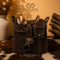 Hand-tooled genuine leather saddlebag crossbody bag in chocolate brown with floral tooling, wooden saddle horn, and gold turn-lock closure - western cowhide handbag