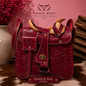 Hand-tooled genuine leather saddlebag crossbody bag in cherry red with floral tooling, wooden horn and cantle, and brass turn-lock - western cowhide handbag